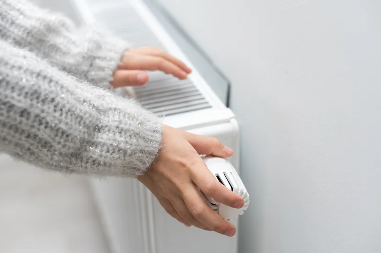Člověk upravuje ventilátor radiátoru pro efektivní vytápění.