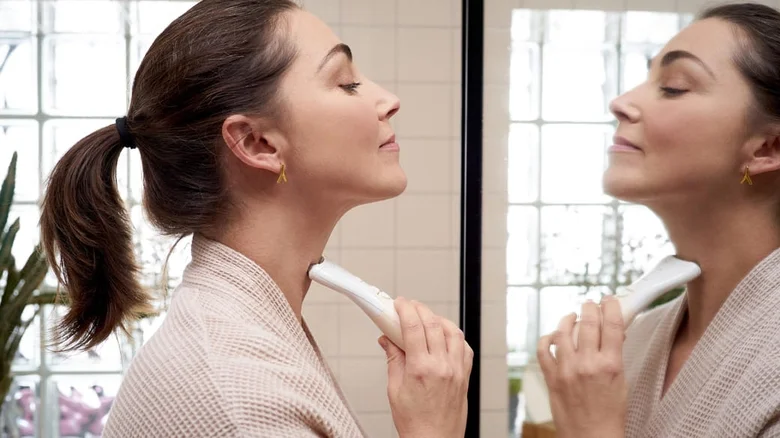 Žena používá zařízení na odstranění podbradku