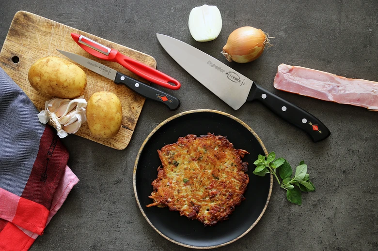 Hotové bramborová placka s surovými ingrediencemi na pozadí.