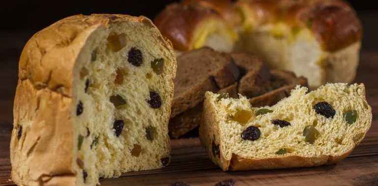 Tradiční italský koláč Panettone s ovocem na dřevěném podkladu