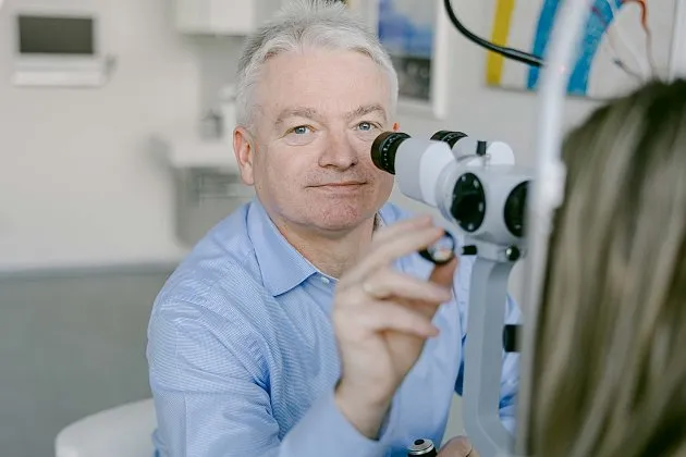 Oční lékař provádí oční vyšetření pacientce