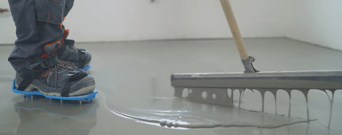 Pracovník hladí betonovou podlahu třískou