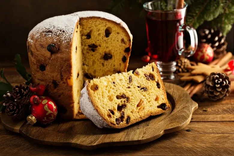 Tradiční italský koláč panettone s rozinkami na vánočním stole.