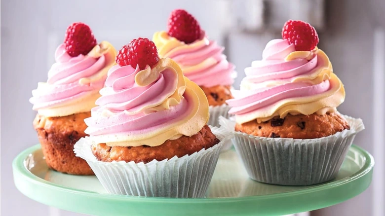 Růžové nadýchané muffiny s malinami na talíři