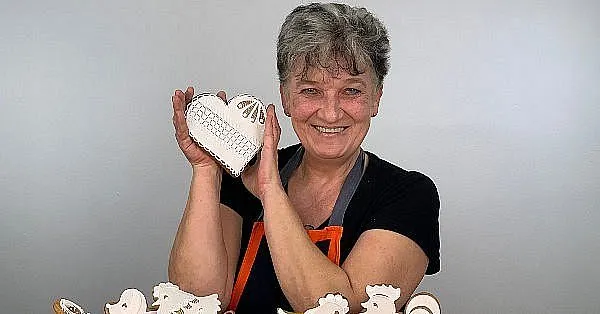 Žena drží zdobený srdcovitý perníček