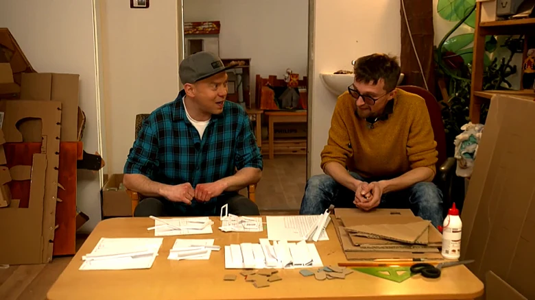 Muži pracují s kartonem doma na DIY projekt