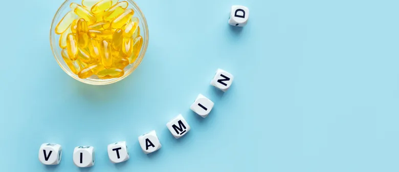 Kapsule vitamínu D na modrém pozadí