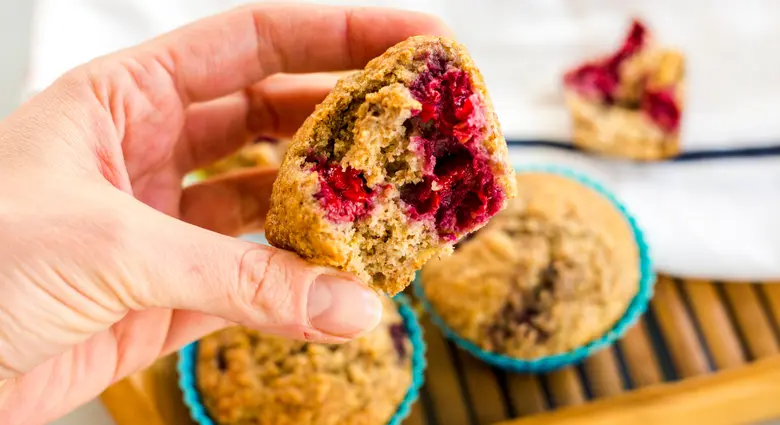 Rukou držená borůvková muffinka s viditelnými plody uvnitř