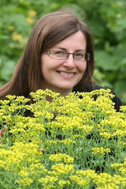 Žena s kvetoucí routou v zahradě