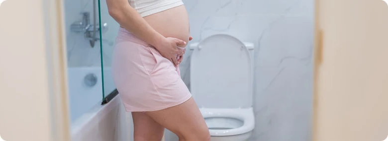 Těhotná žena v koupelně, před toaletou