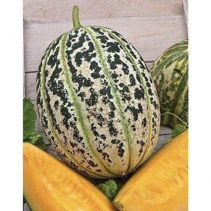 Celý meloun s oranžovou dužinou na dřevěném povrchu.