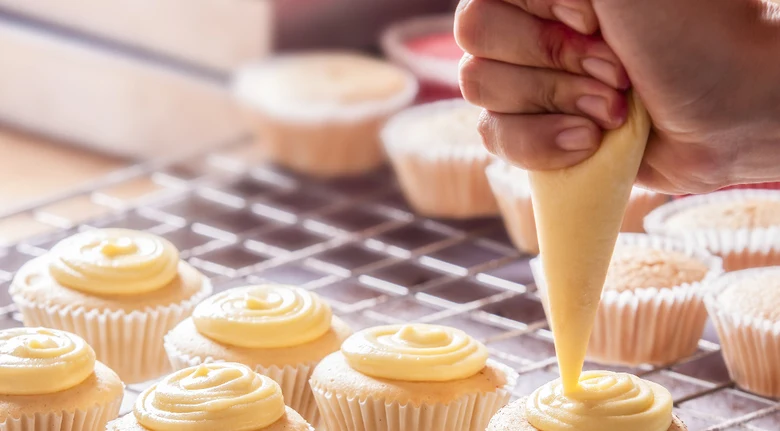 Ruční aplikování vanilkového krému na muffiny