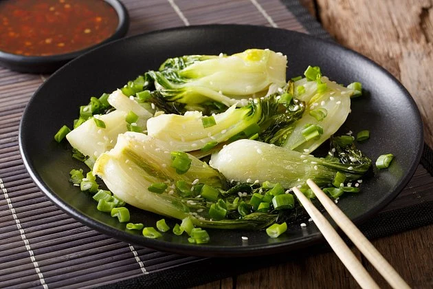 Pak choi připravený k jídlu na černém talíři