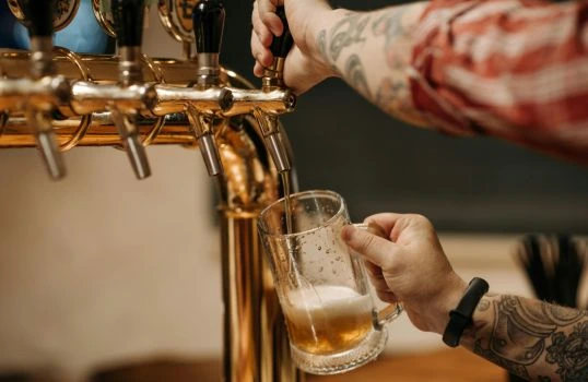 Pivo naléváno z kohoutku do sklenice