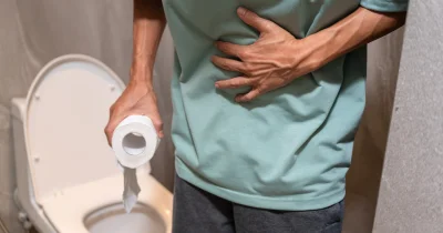 Muž s bolestí v břiše u toalety