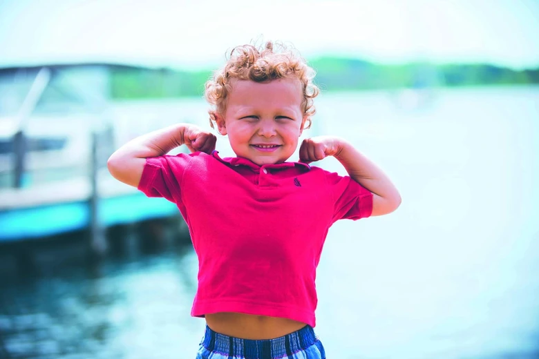 Happy child flexing arms