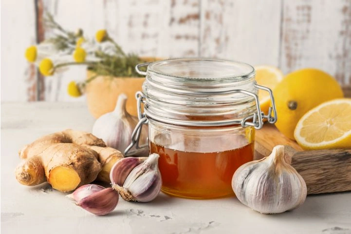 Sklenice medu s česnekem, zázvorem a citrony pro kašel.