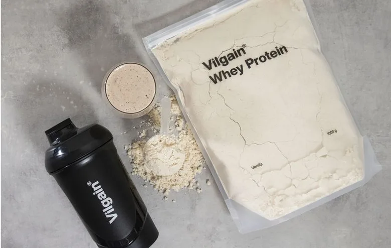 Sáček bílkoviny Whey Protein s lžičkou a mixérem.