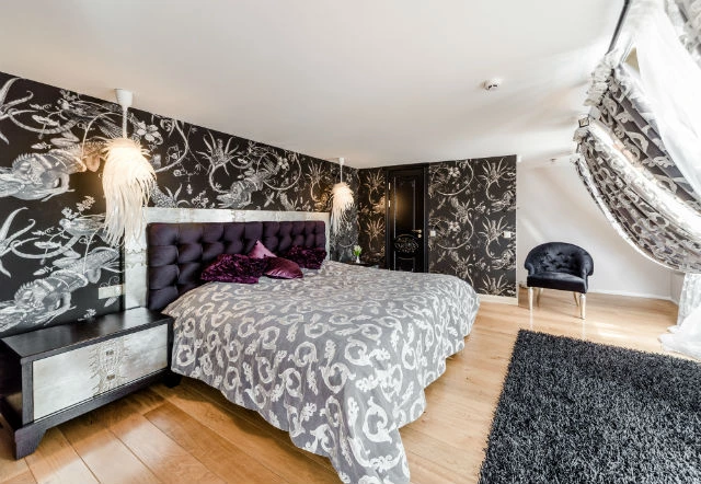 Ložnice v glamour stylu s černými tapetami a luxusním nábytkem.