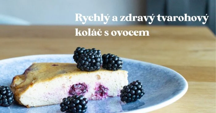 Kousek tvarohového koláče s černými borůvkami na talíři.
