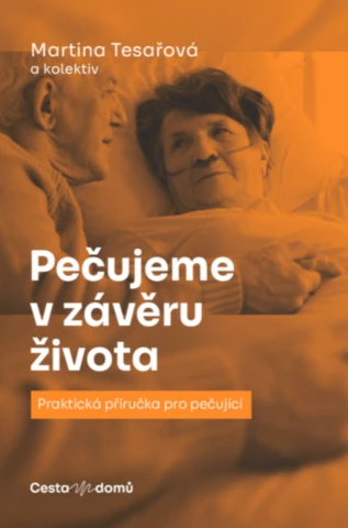Starší žena leží v posteli s osobou poskytující péči.