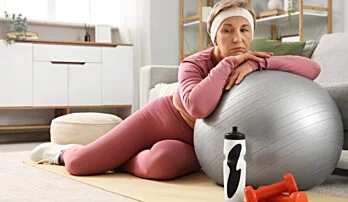 Žena cvičí s fitballem pro úlevu od bolesti zad.