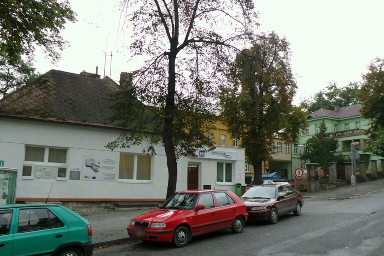 Ulice v Kladně s parkovanými auty a budovami včetně neurologické ordinace