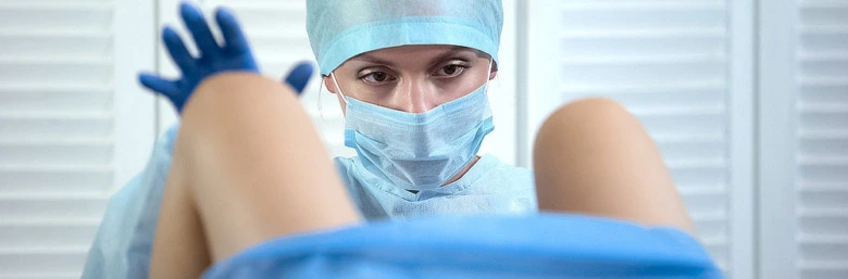 Gynekologka vyšetřuje pacientku během konizace čípku.