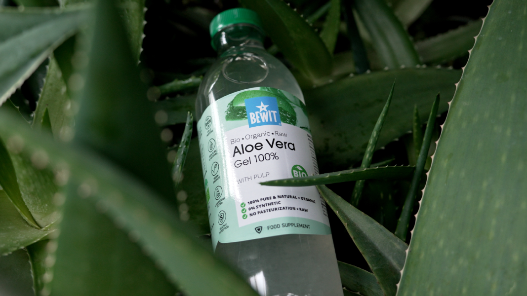 Sklenička s gely z aloe verry mezi rostlinami.