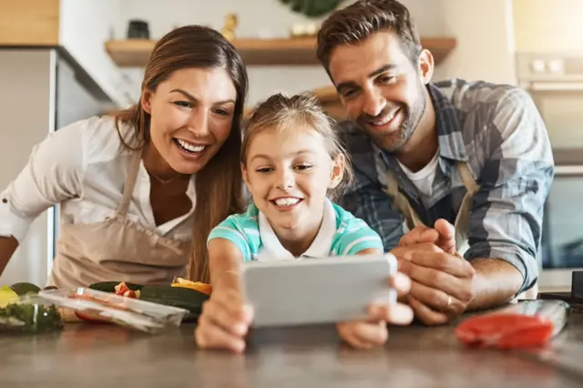 Family using smartphone in kitchen