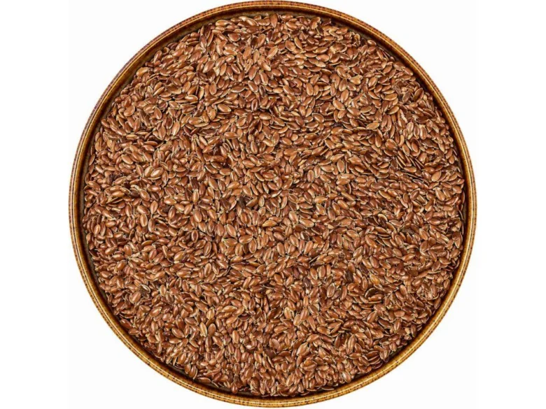 Kruhová miska plná hnědých semen lnu setého.