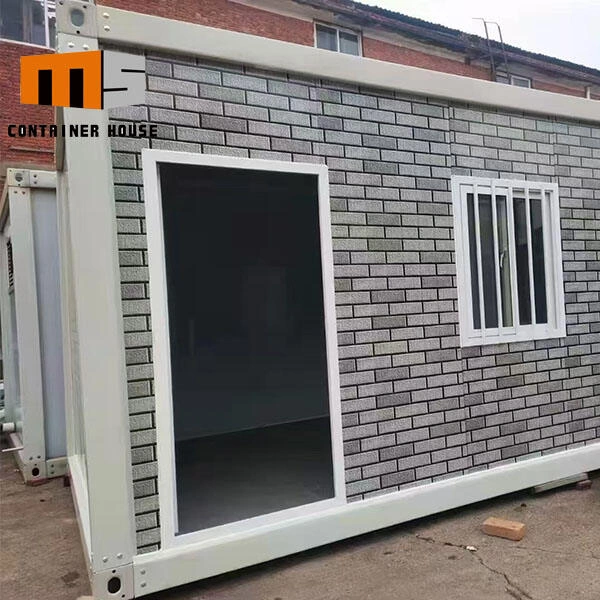 Hotový kontejnerový dům s šedou cihlovou fasádou a bílým oknem.