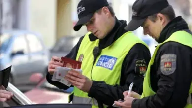 Policiisté kontrolují řidičský průkaz u auta.