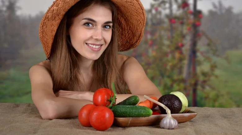 Žena s čerstvými zeleninovými produkty na stole