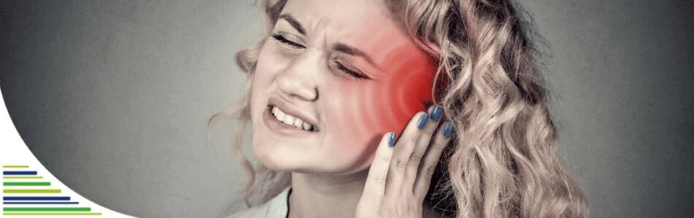Žena s bolestí v uchu drží ruku k bolavému uchu.