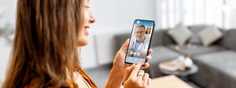 Žena telefonuje s lékařem na mobilu pro telemedicínskou konzultaci.