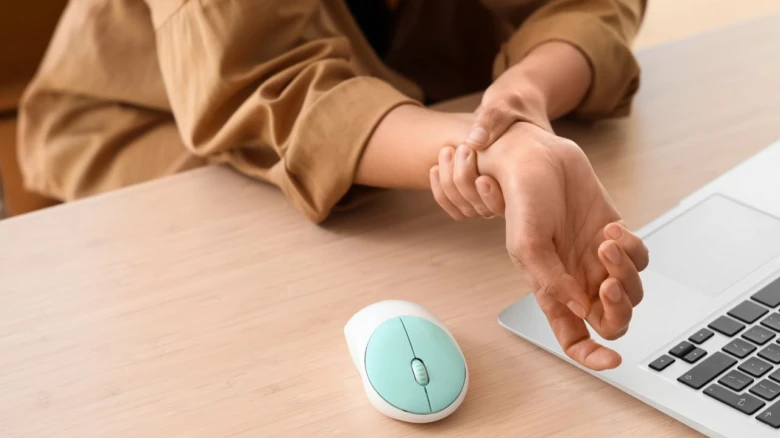 Person holding wrist in pain