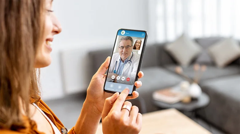 Žena telefonuje zdarma s lékařem na videotelefonu.