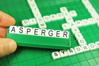 Ruka drží kostky s nápisem Asperger nad jinými slovy syndrom.