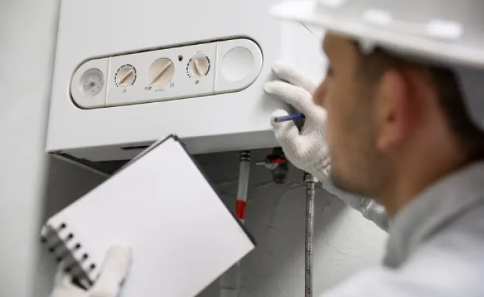 Technik kontroluje topení při práci s energiemi.