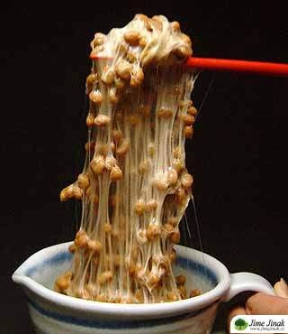 Fermentované sójové boby (natto) zvedané čínskými hůlkami.