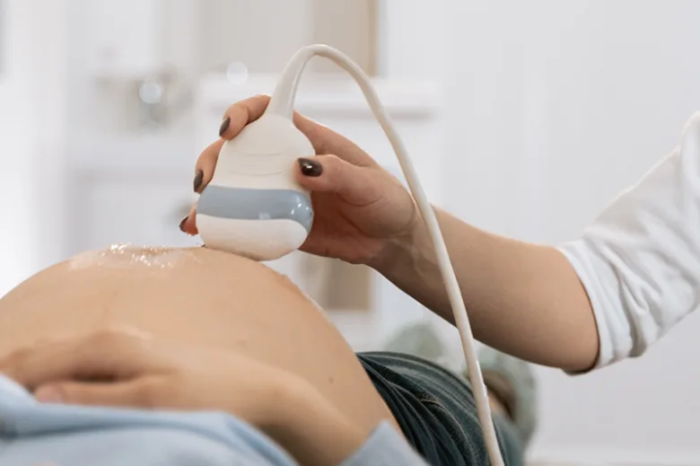 Ultrazvukové vyšetření břicha těhotné ženy pro určení pohlaví dítěte.