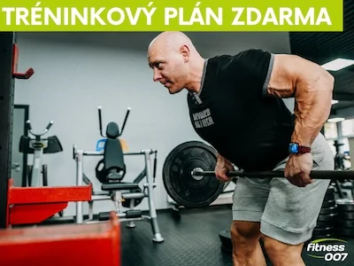 Muž provádí mrtvý tah s činkou v posilovně.