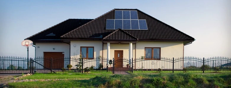 Dům s fotovoltaickými panely na střeše ukazuje výhody solární energie.