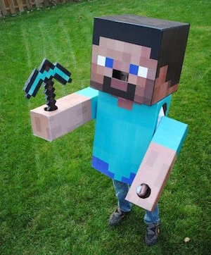 Lidska postava v kostýmu z kartonu ve stylu hry Minecraft.