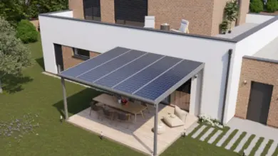 Moderní zahradní pergola s fotovoltaickými panely na dřevěné terase.