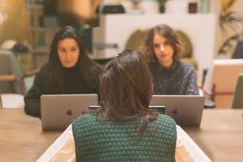 Three women at table with laptops