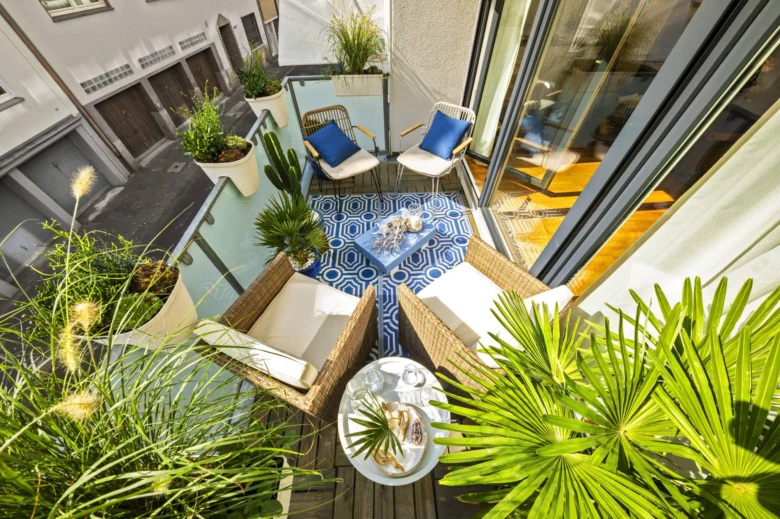 Balkon s rostlinami v květináčích na modrém podlaze.