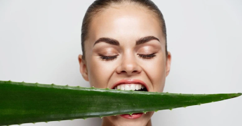 Žena sčichá čerstvý list aloe vera pro zdraví.