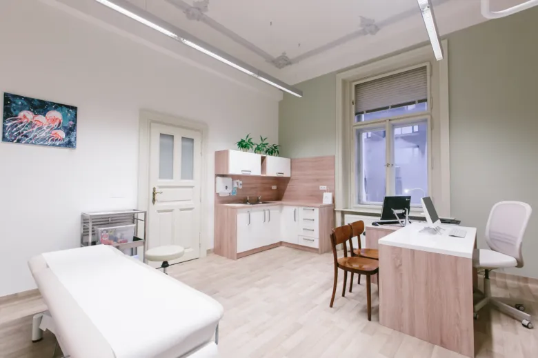 Moderní lékařský pokoj s lůžkem pro vyšetření pacienta.